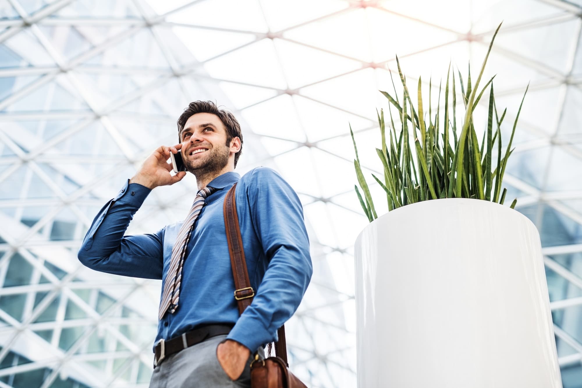A young businessman with smartphone, making a phone call. Copy space.