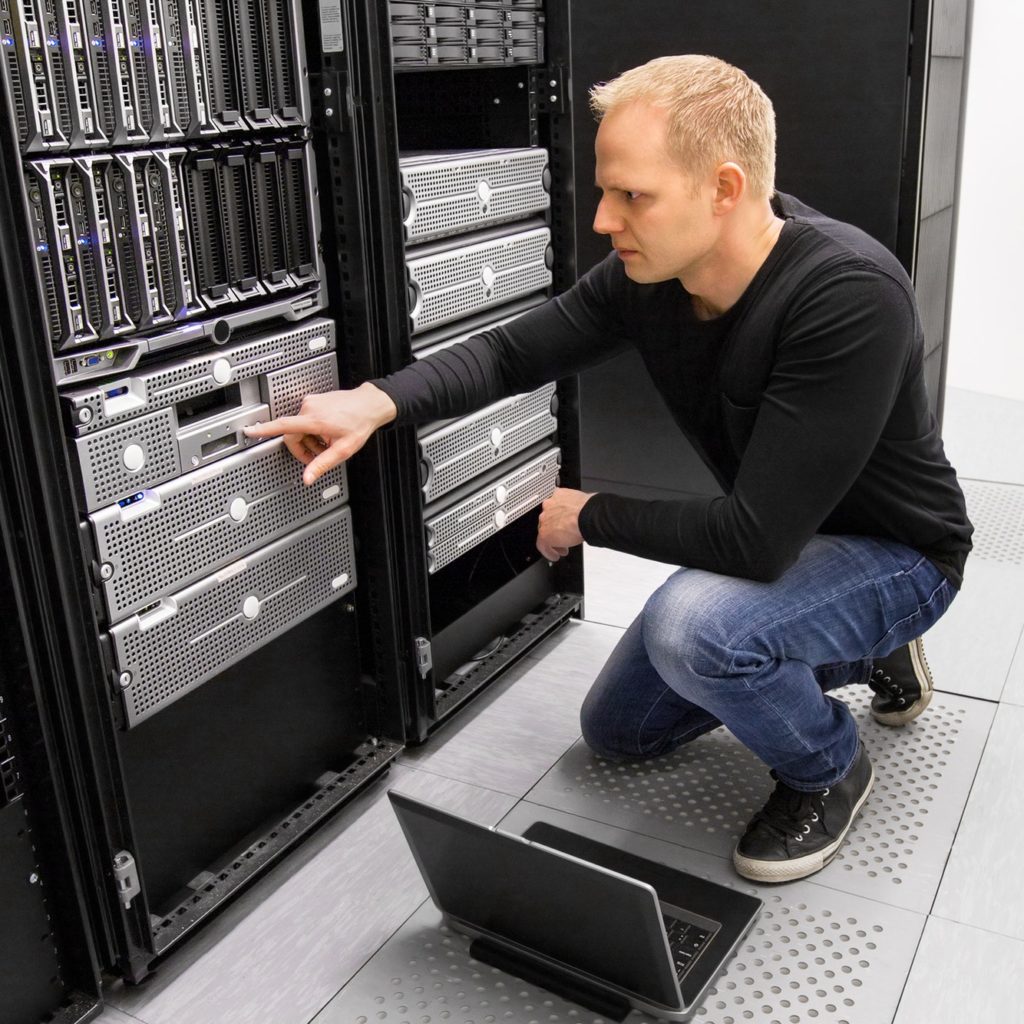It consultant work with laptop in datacenter