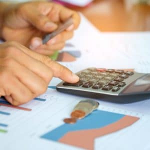 Men are using a calculator to analyze the cost of a credit card.